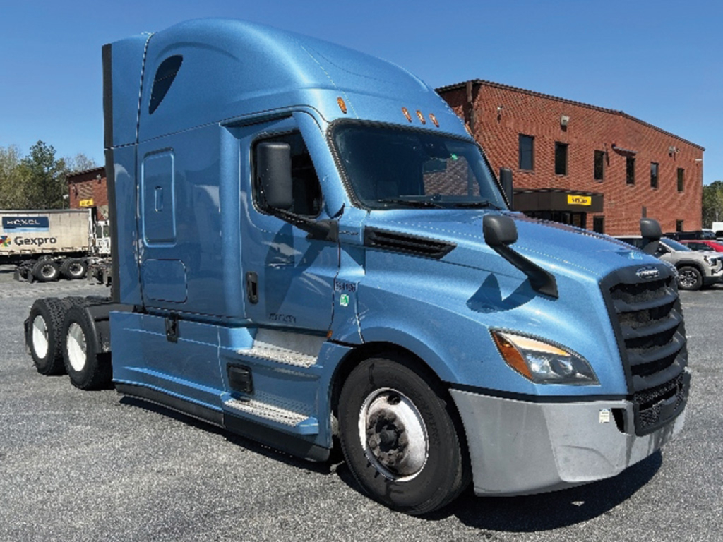 Truck cab view of a blue 2022 Freightliner Cascadia126 conventional sleeper with front grille, headlights, and side mirrors.