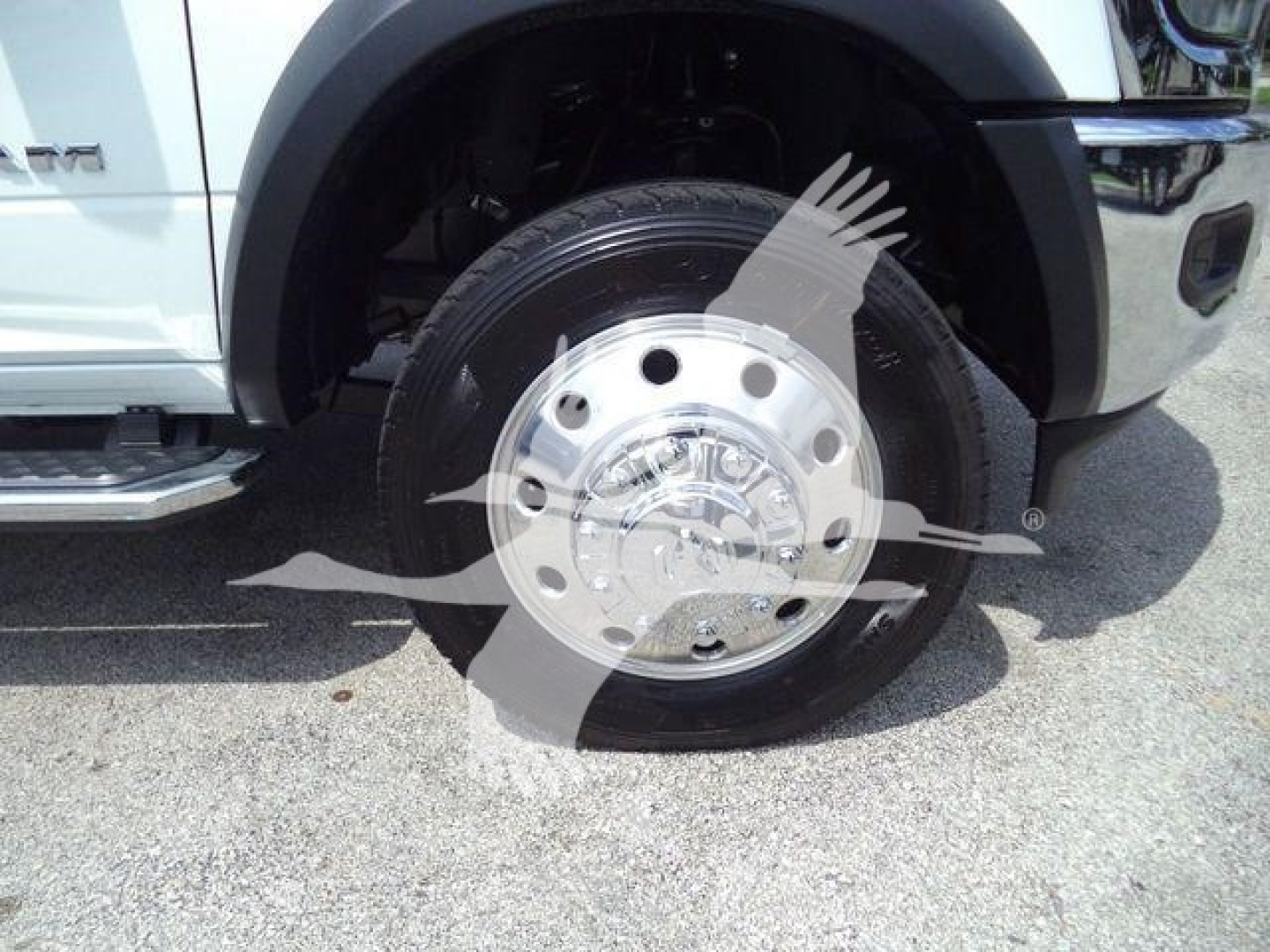 Truck front wheel and fender of a 2024 Ram 5500 SLT showing polished hubcap and tire.