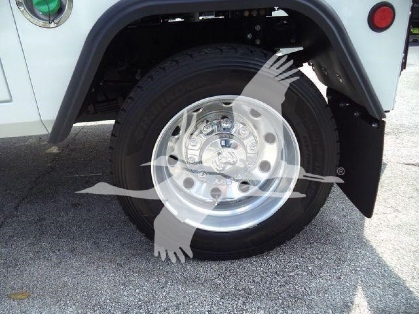 Front wheel and fender of a white Ram 5500 truck showing tire, wheel, and fender; watermark logo overlay across center.