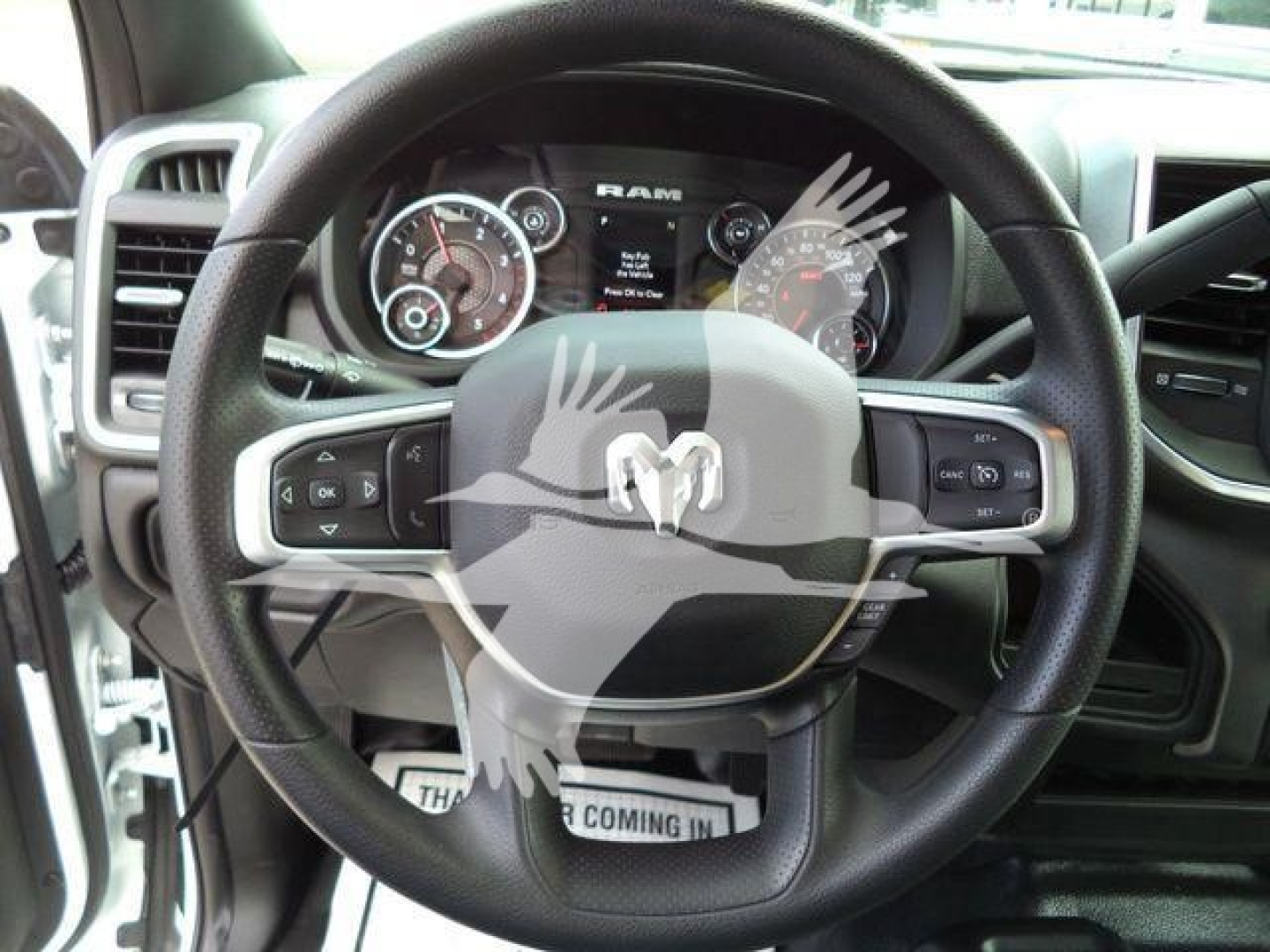 Ram truck steering wheel and dashboard showing RAM logo in center, instrument cluster visible