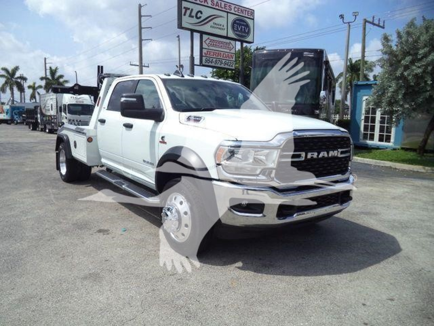 White 2024 Ram 5500 SLT tow truck with winch, front grille RAMEM styling, large dual rear wheels, black fender flares. visible text on image includes RAM badge and dealership signage in background.