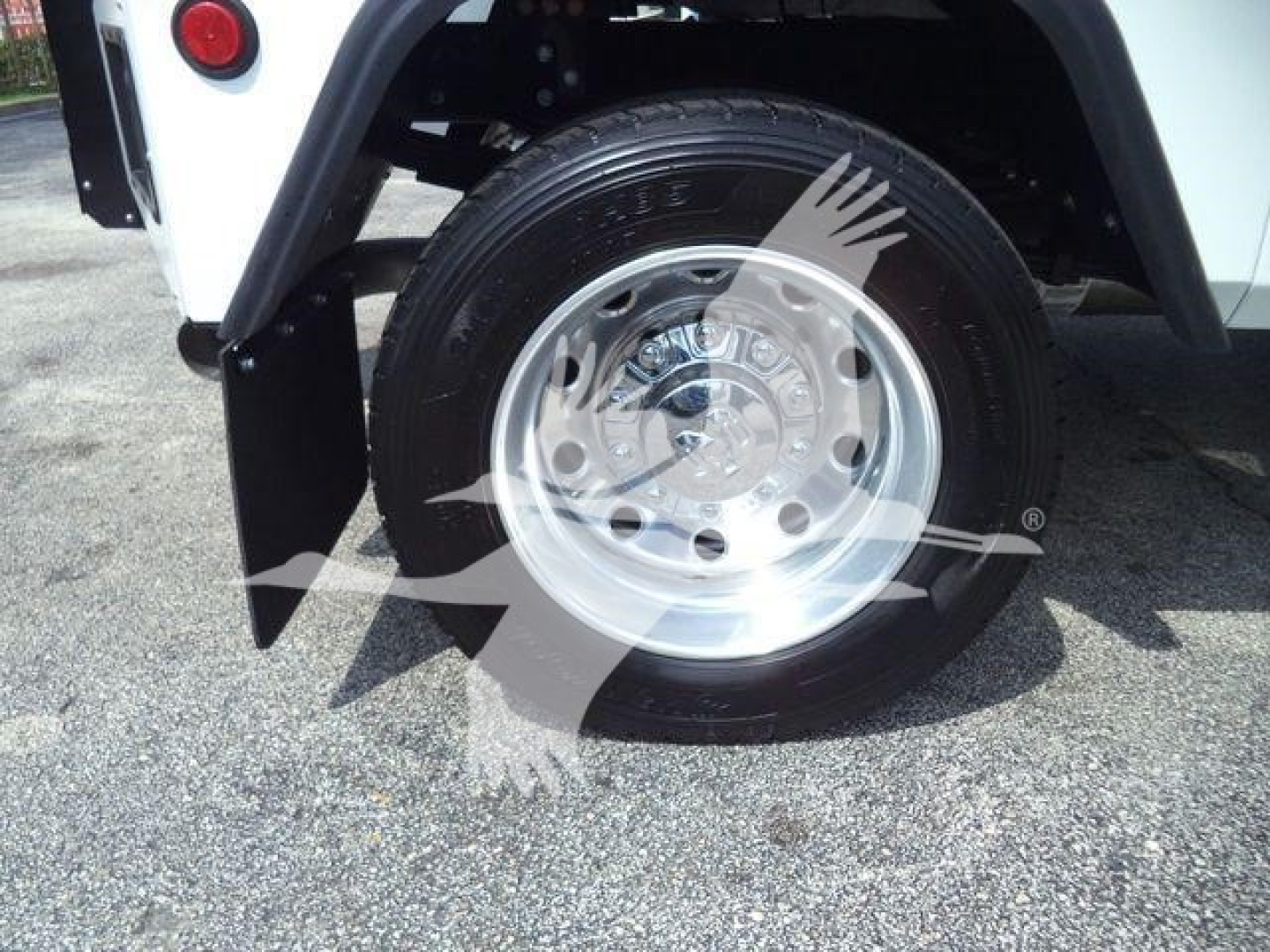 Truck wheel and fender area showing aluminum wheel and tire mounted on Ram 5500 SLT with white body panel