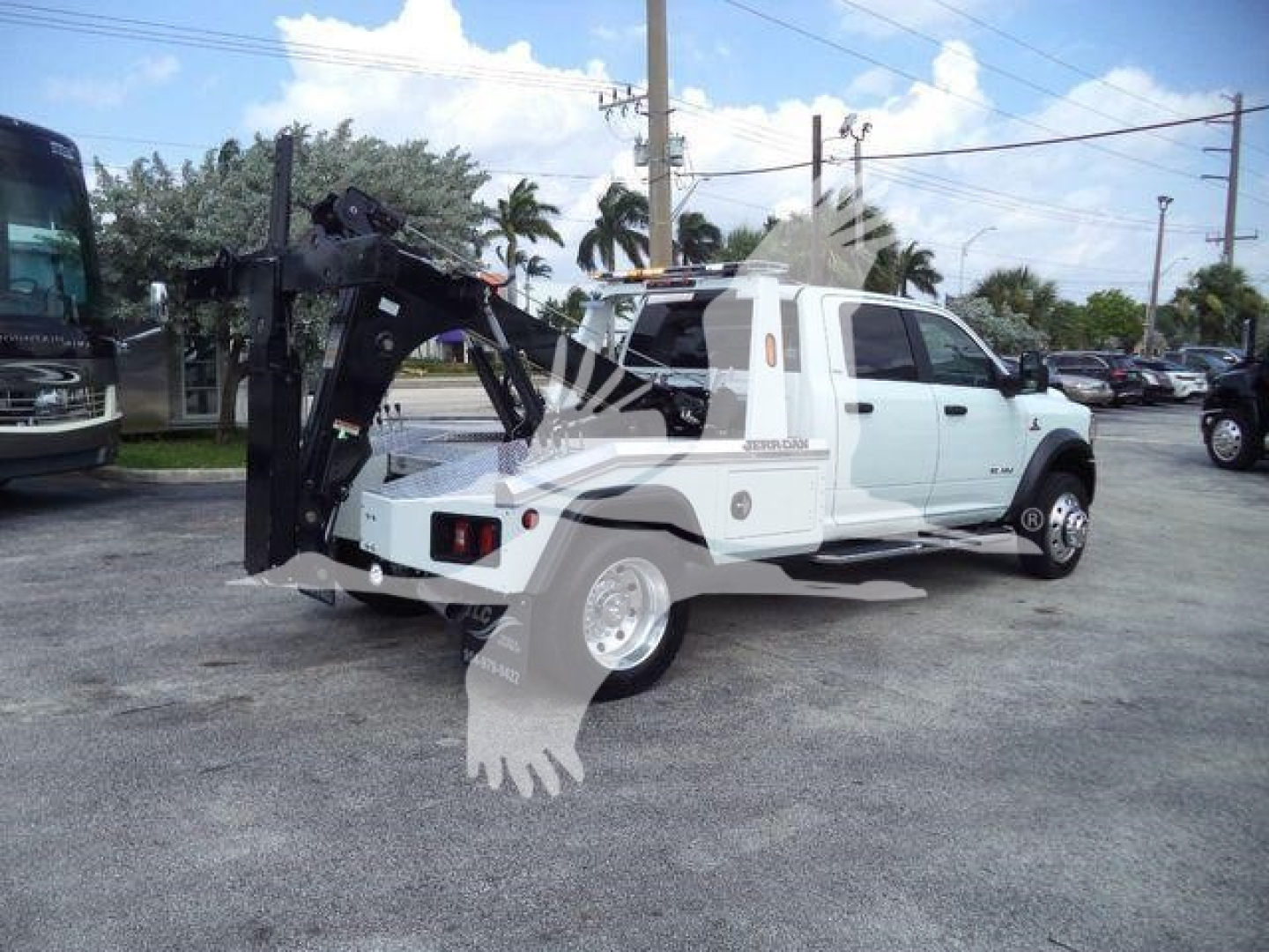Ram 5500 tow truck with rear-mounted winch system and white cab, MPL40RAM5500FM stock number plate visible in lot.