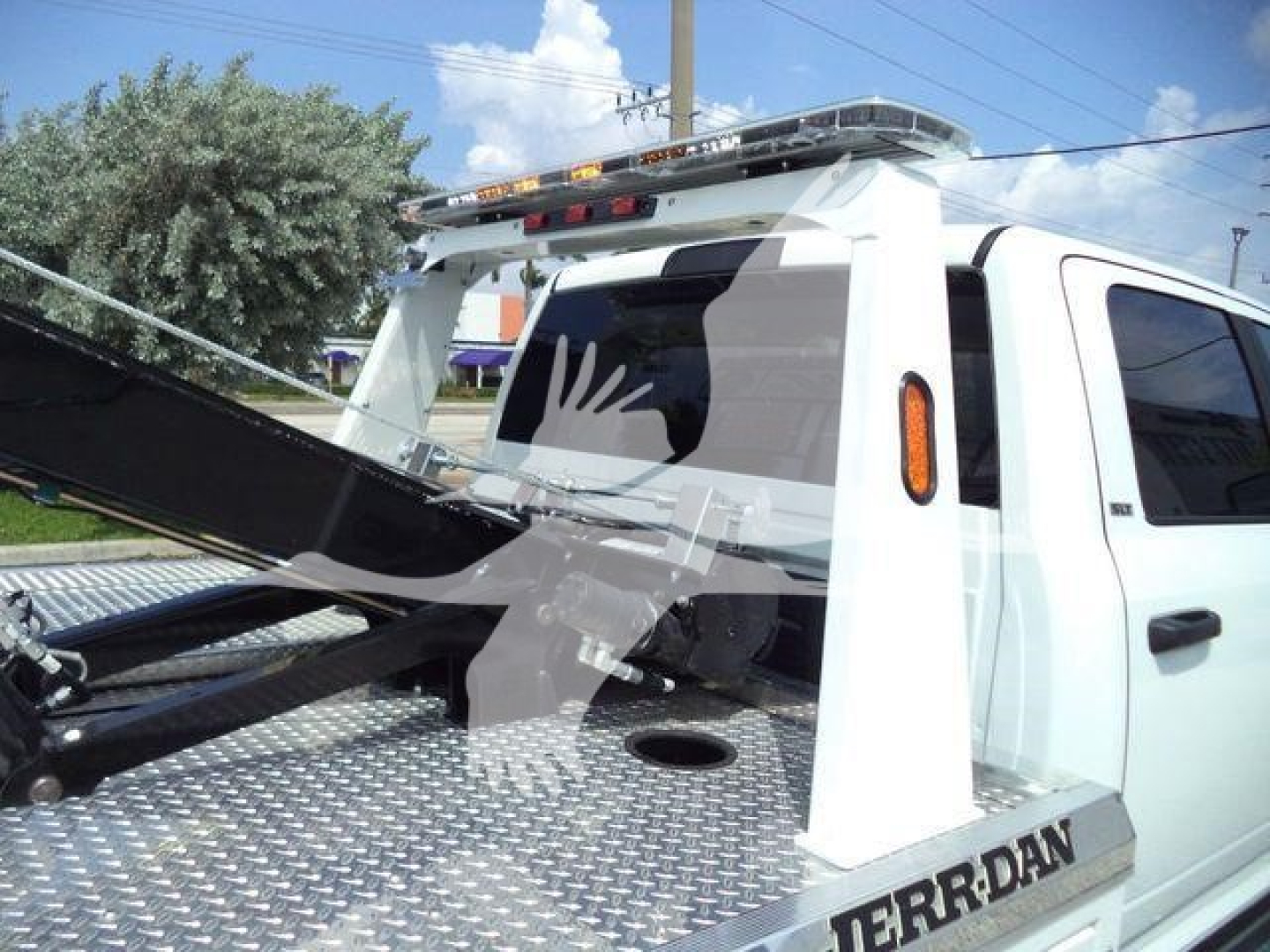 Ram 5500 tow pickup with winch setup mounted on steel diamond plate bed and Rams logo; rear cab structure visible.