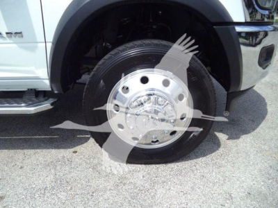Truck front wheel and fender of a 2024 Ram 5500 SLT showing polished hubcap and tire.