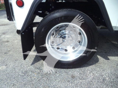 Truck wheel and fender area showing aluminum wheel and tire mounted on Ram 5500 SLT with white body panel