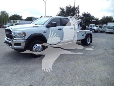 Ram 5500 SLT winch truck shown in side/front view with white body and twin rear axles, loading bed rack, logo watermark over image.