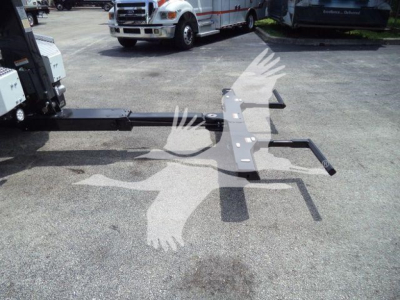 Winch-mount setup on a Ram 5500 chassis showing a long black steel guide and mounting plate with hook bars and electrical connectors.