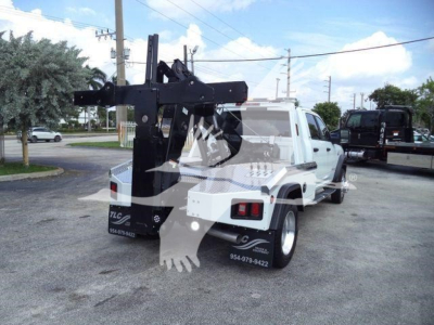 Truck bed with a mounted hydraulic winch system on a white Ram 5500 chassis, rear view showing winch frame and mounting hardware.