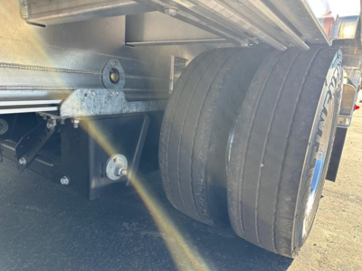 Mac drop deck trailer wheel view showing dual tires and underside components.