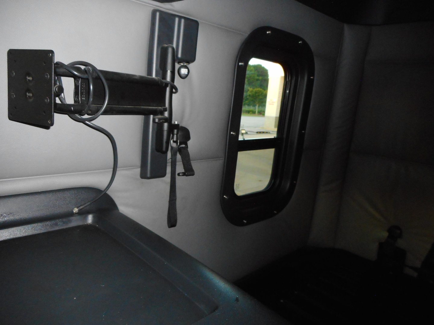 Cab interior of a 2022 Freightliner Cascadia 126 showing a mounted bracket and window on the sleeper wall.