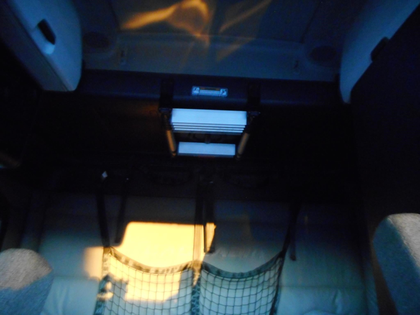 Cab interior showing under-dash storage and a small white object; dim lighting.