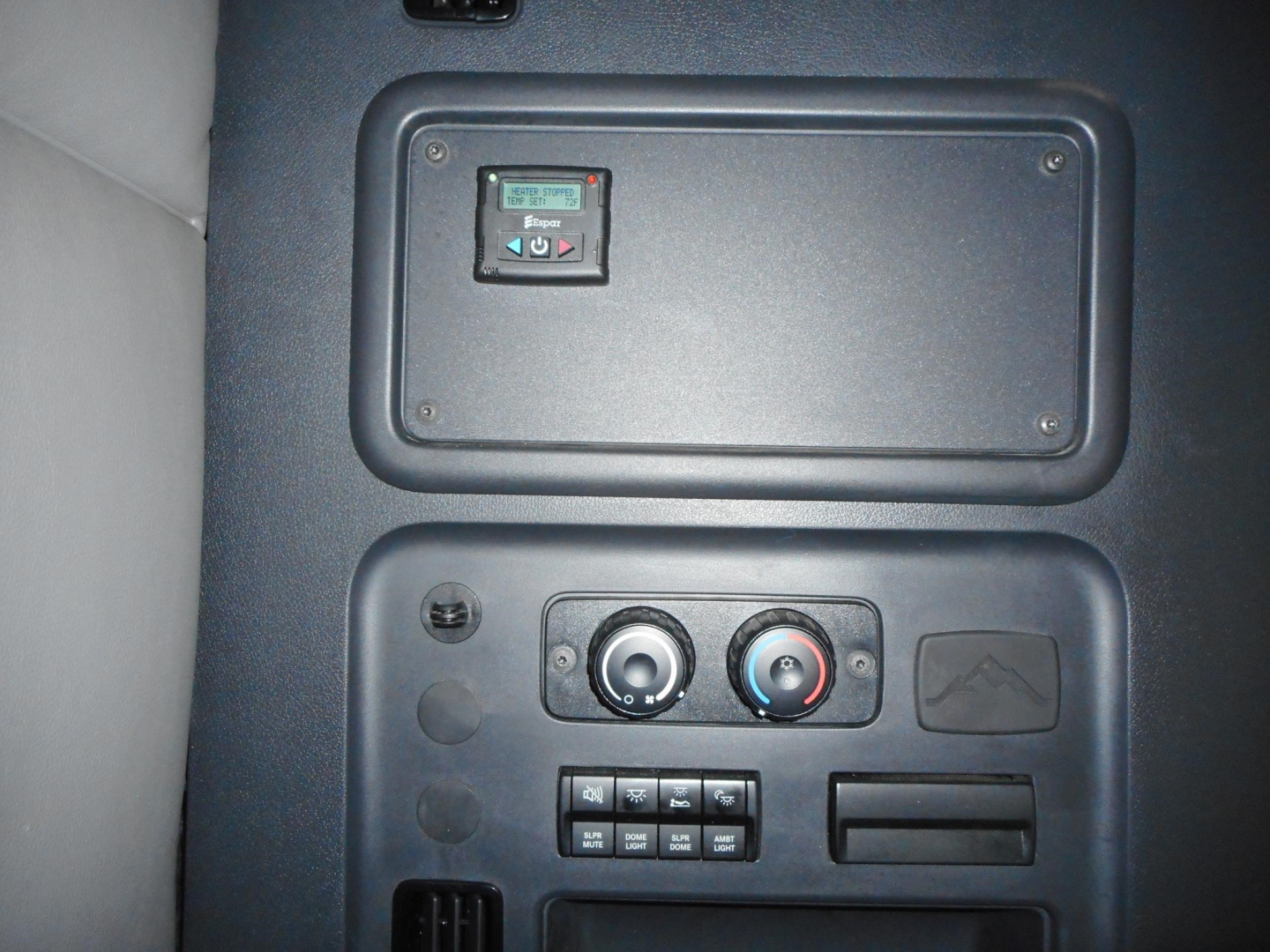 Interior dash area of a Freightliner Cascadia showing control panel, vents, and small display screen.