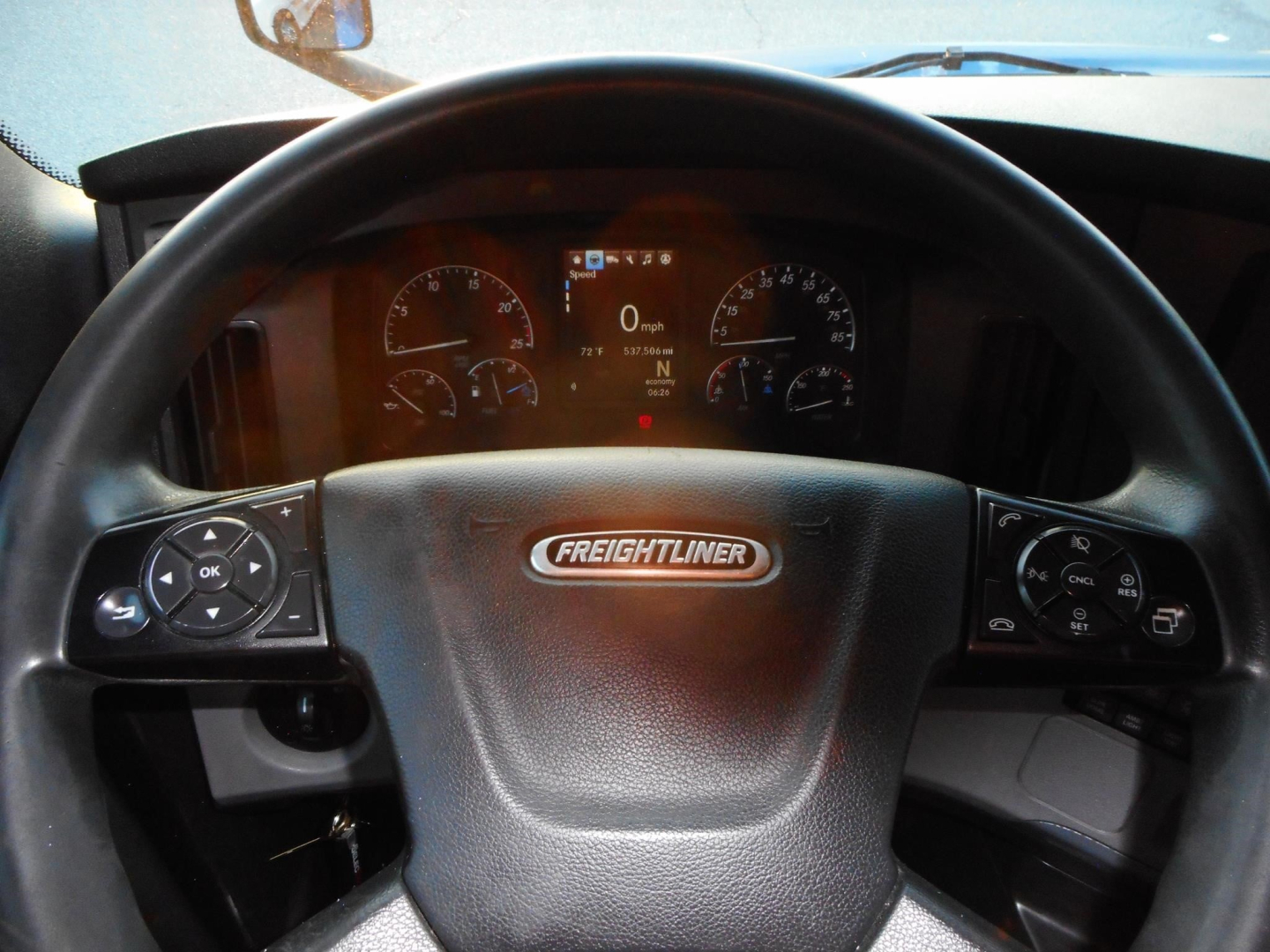 Dashboard view of Freightliner Cascadia steering wheel with instrument cluster visible
