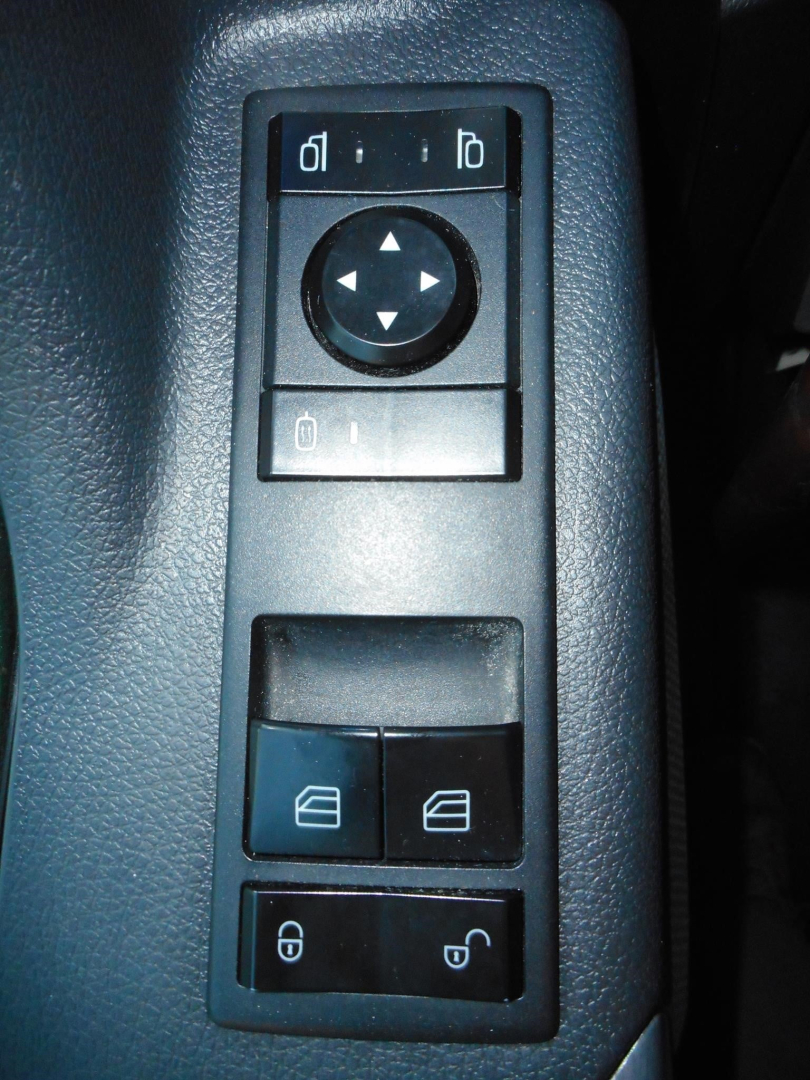 Ceiling panel in Freightliner Cascadia shows window/lock controls and directional pad; part of interior door switch cluster.