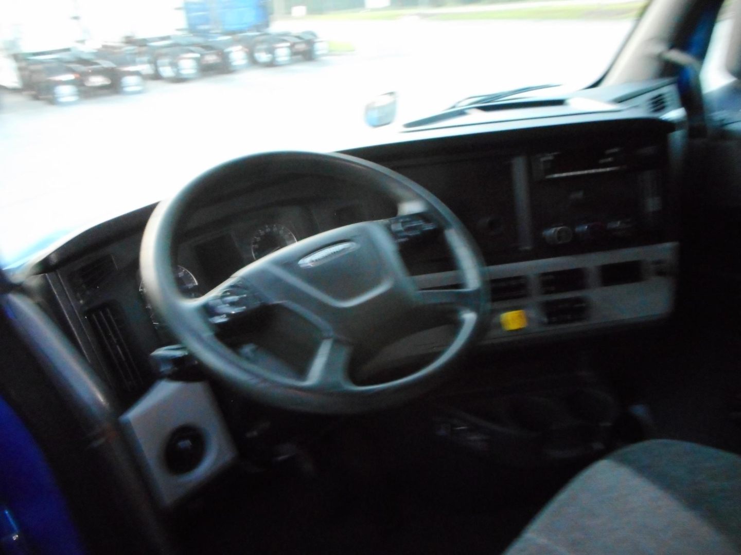 Freightliner Cascadia interior dashboard and steering wheel view.