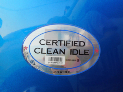 Certified Clean Idle badge sticker on blue truck surface with serial numbers and small barcode