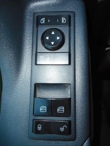 Ceiling panel in Freightliner Cascadia shows window/lock controls and directional pad; part of interior door switch cluster.
