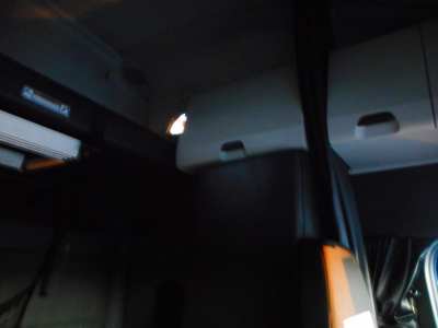 Freightliner Cascadia interior with sleeper cabin doors and curtains visible; partial dashboard area.