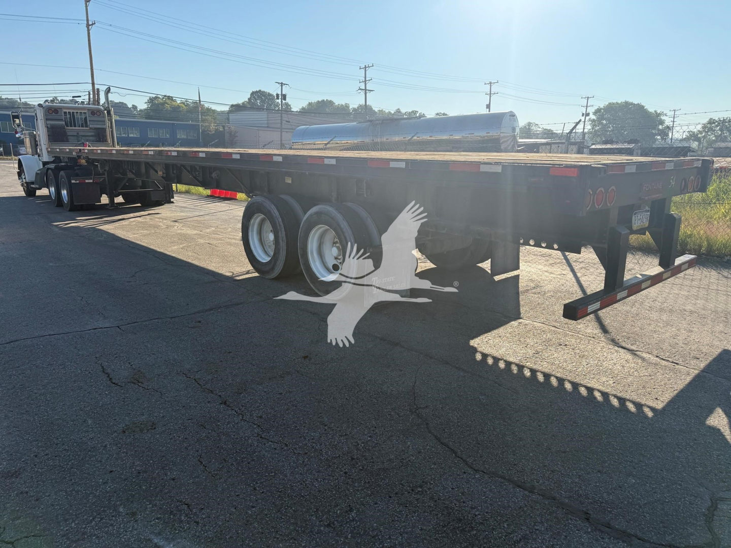 Flatbed trailer showing Fontaine XTP 4880SS2 logo, dual rear axles, long flat deck with side rails, and tandem wheels. Text: None clearly visible on the trailer signage.