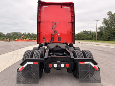 Kenworth T680 rear-view showing dual rear axles and mudflaps, red sleeper cab with back door open, fifth wheel and chassis visible.