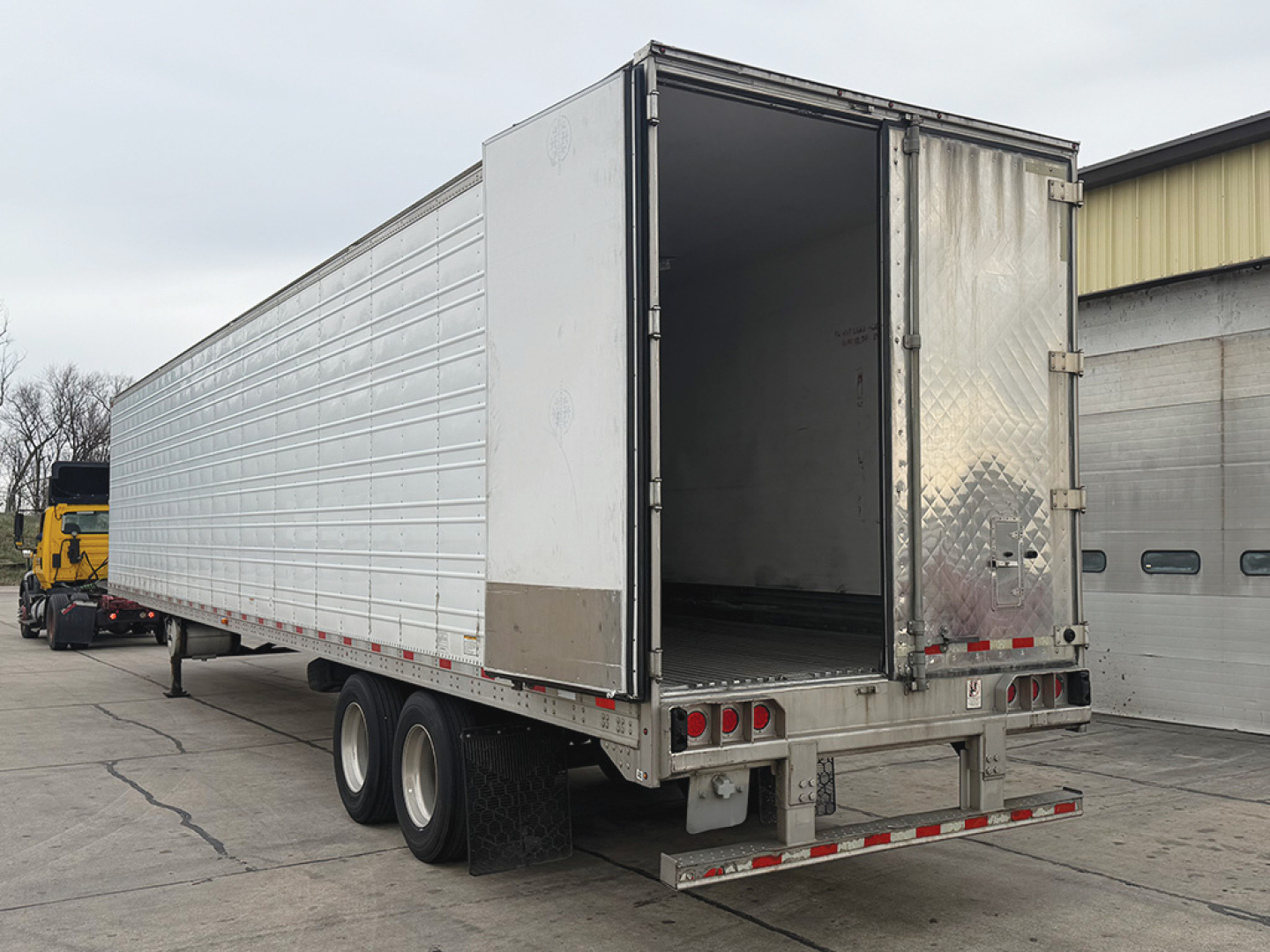 Great Dane Everest SS trailer with open rear doors showing aluminum panel walls and dual rear axles.