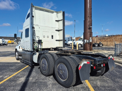 Truck cab and chassis showing rear view with fifth wheel and dual rear axles on a used International LT625 tractor.