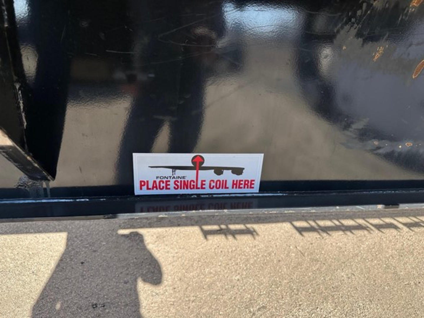 Sticker on Fontaine equipment reading 'PLACE SINGLE COIL HERE' with red and black logo, mounted on black surface near ground.