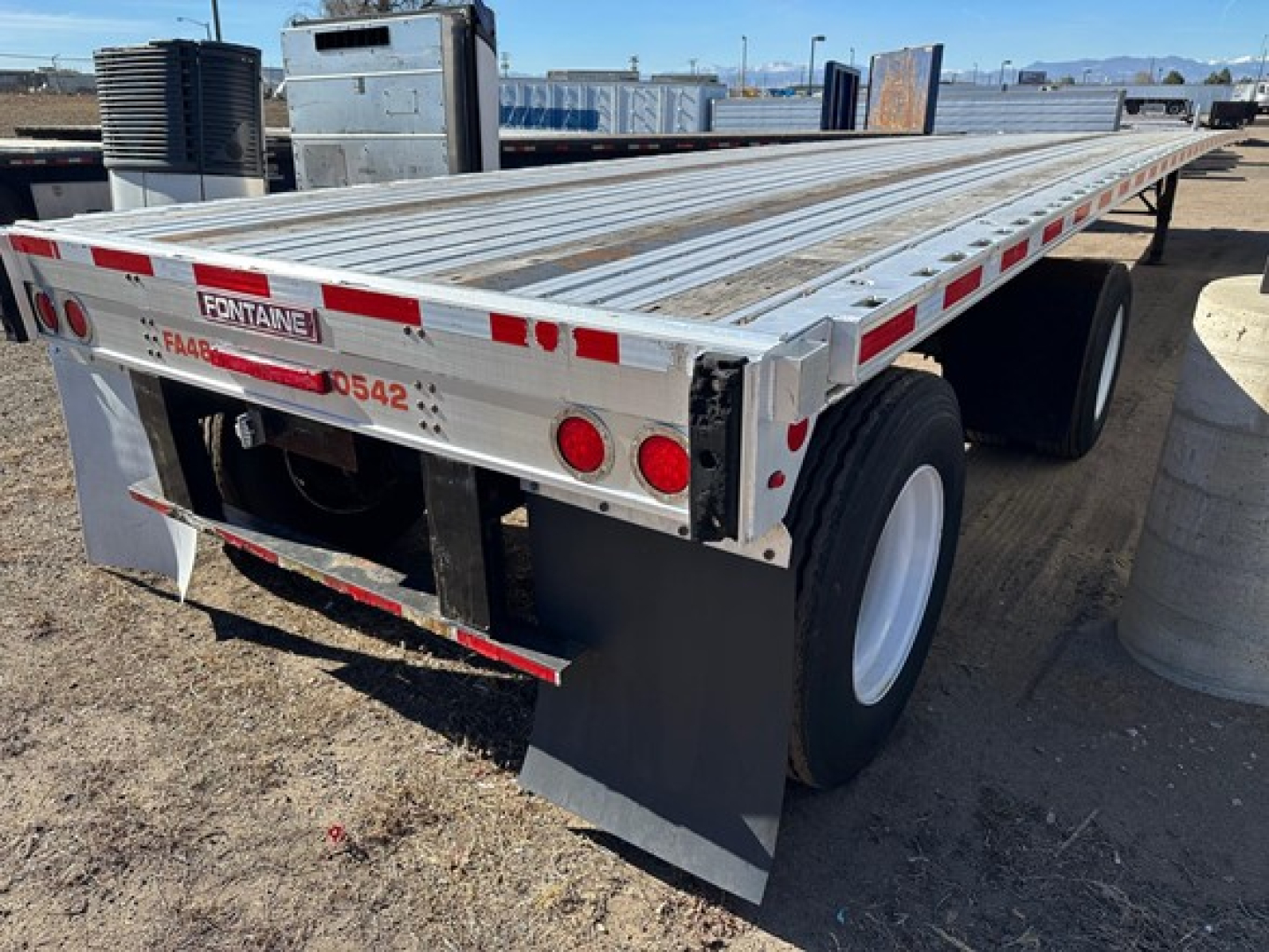 Fontaine Spread Air Combo Flatbed trailer with dual rear axles and aluminum deck showing reflective tape and ramps.