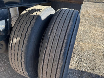 Two rear truck tires on a Fontaine spread air combo flatbed trailer showing tread wear and sidewall details.