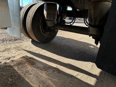 Underview of Fontaine spread air combo flatbed trailer showing dual tandem axles and suspension components.
