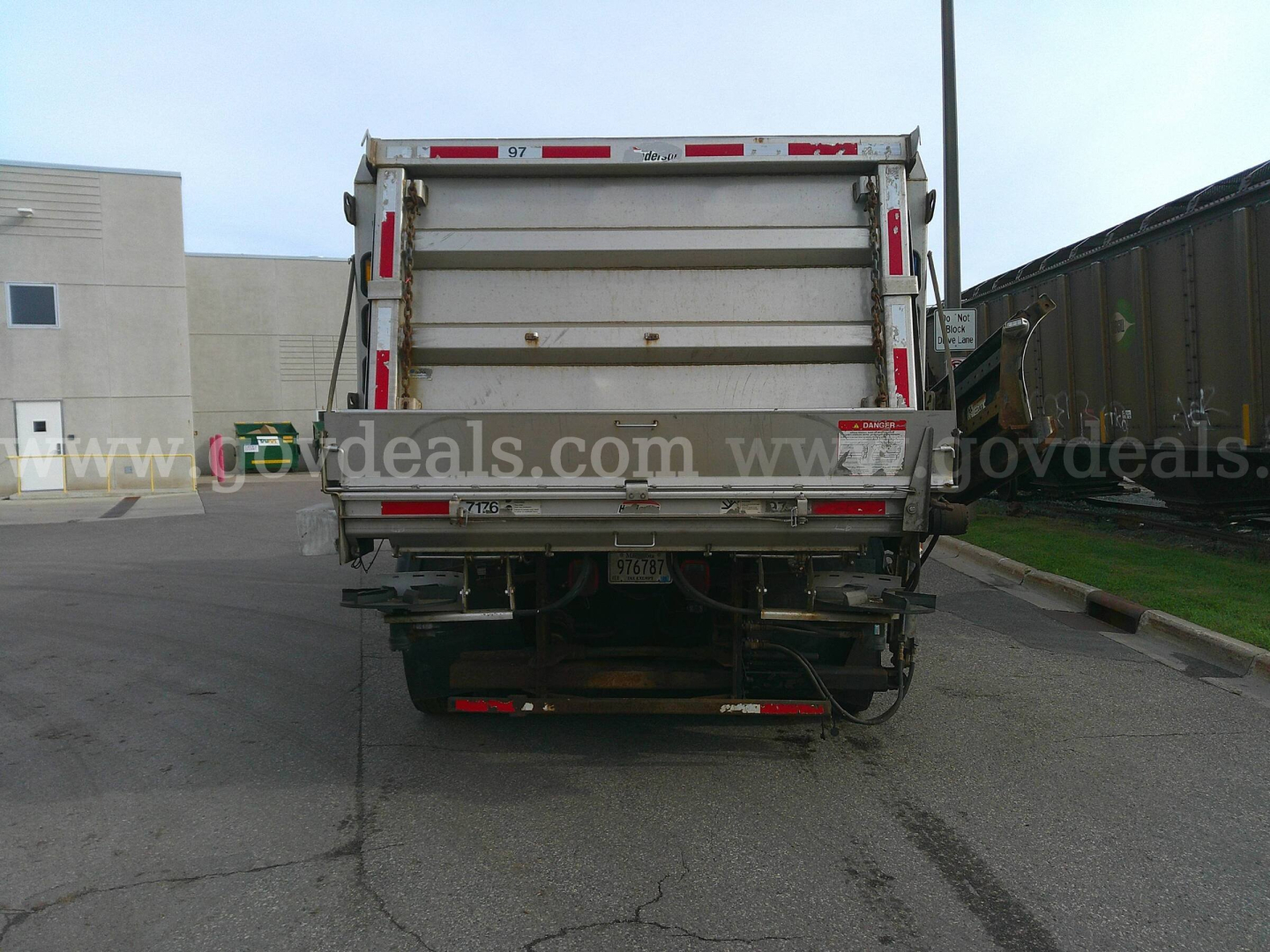 Rear view of 2013 International WorkStar 7600 dump truck with plow category, showing tailgate and hitch area.