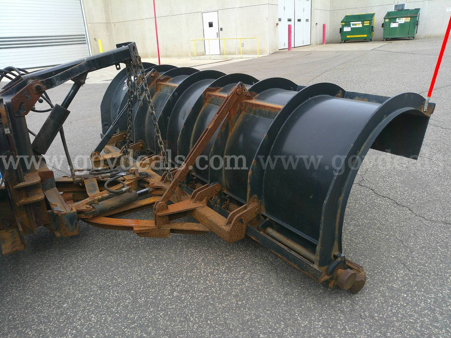 Snowplow attachment for a 2013 International WorkStar 7600 showing large metal blade and mounting frame in a parking lot.