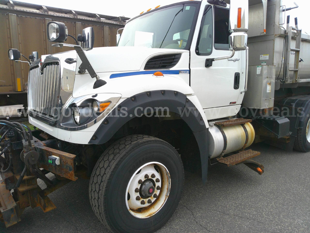 Truck side view showing 2013 International WorkStar 7600 plow truck with front fender, large wheel, and plow mount.