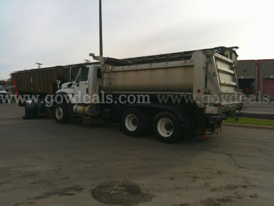 2013 International WorkStar 7600 dump truck with plow, side view showing bed and rear wheels.