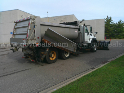 International WorkStar 7600 dump truck with snow plow attachment in a parking lot, side and rear views visible.