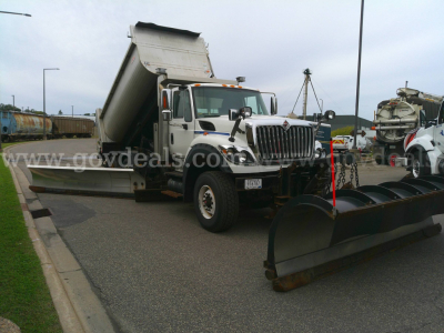 Tractor-style truck with plow attachment and dump bed in a parking lot. International WorkStar 7600 with plow equipment.