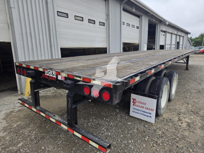 Trailer: 2018 Dorsey steel flatbed shown from rear-left side with dual rear axles and wood deck; outfitted with taillights, reflectors, and a black framed undercarriage.