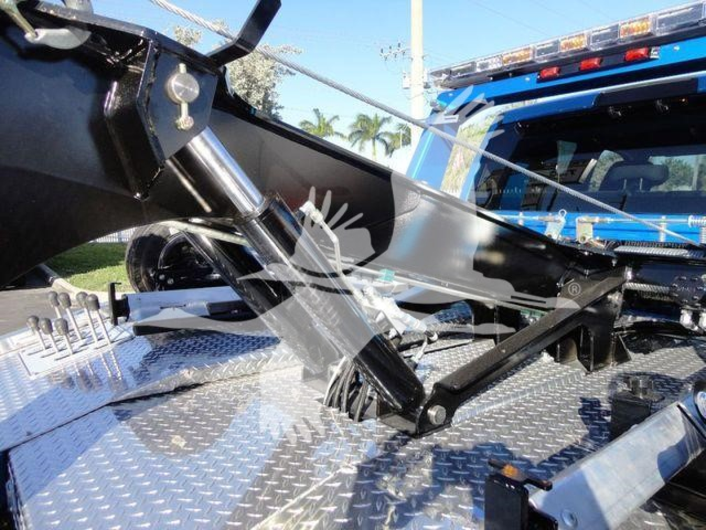 Ram 5500 SLT truck bed with hydraulic winch mechanism and metallic diamond plate surface visible