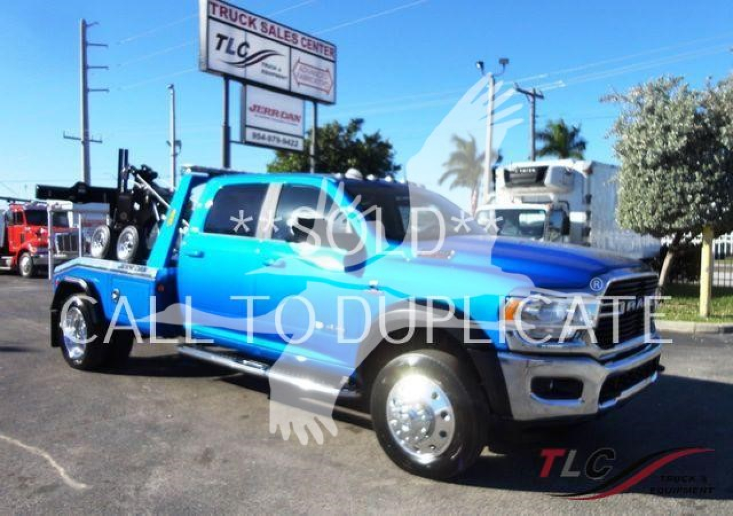 Blue Ram 5500 truck with tow winch setup, stock number J53154 visible at a truck lot.