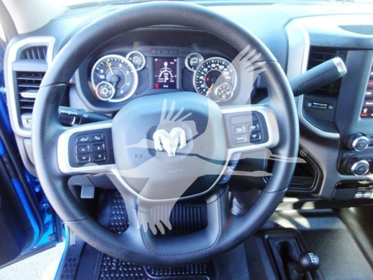 Ram steering wheel and instrument cluster in a 2024 Ram 5500 SLT, with center multi-function controls on the steering wheel and vehicle gauges visible.