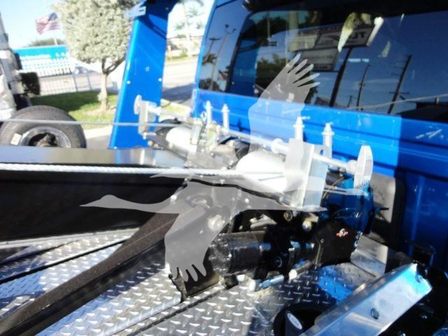 Ram pickup bed showing winch mounting hardware and remote control on diamond plate surface.