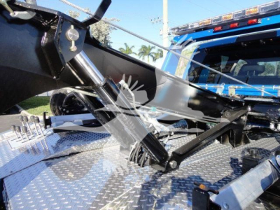 Ram 5500 SLT truck bed with hydraulic winch mechanism and metallic diamond plate surface visible
