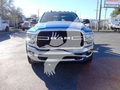 Ram 5500 pickup truck front view with large grille and RAM logo, blue exterior, visible chrome bumper, dealership lot in background.