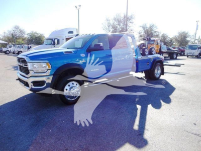 Blue Ram 5500 SLT truck in a dealership lot with a large white bird watermark across the image.
