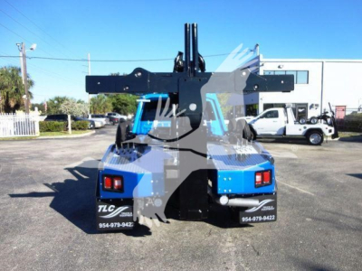 Truck with large boom attachment rear view. Visible text: TLC... on bottom rear panels; phone numbers 954-979-942? and 954-979-9422; blue and black color