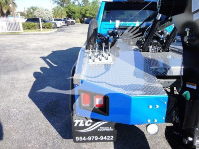 Ram 5500 SLT winch truck portion showing control levers on a diamond-plate toolbox, rear tail light, and TLC Trucks & Equipment plate with phone number 954-979-9422.