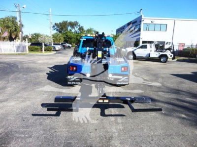 Ram 5500 tow truck with winch and multiple stabilizing bars visible from rear view, in a dealership lot.