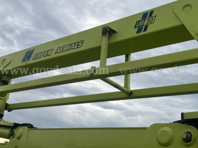 Equipment image showing Aspen Aerials boom with label and UB50 marking on yellow-green structure.