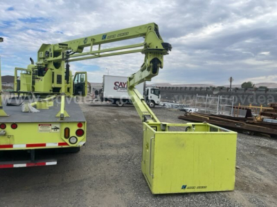 Industrial boom truck with lime-green maintenance arm extending over a yellow toolbox platform; rear of truck visible with safety lights.